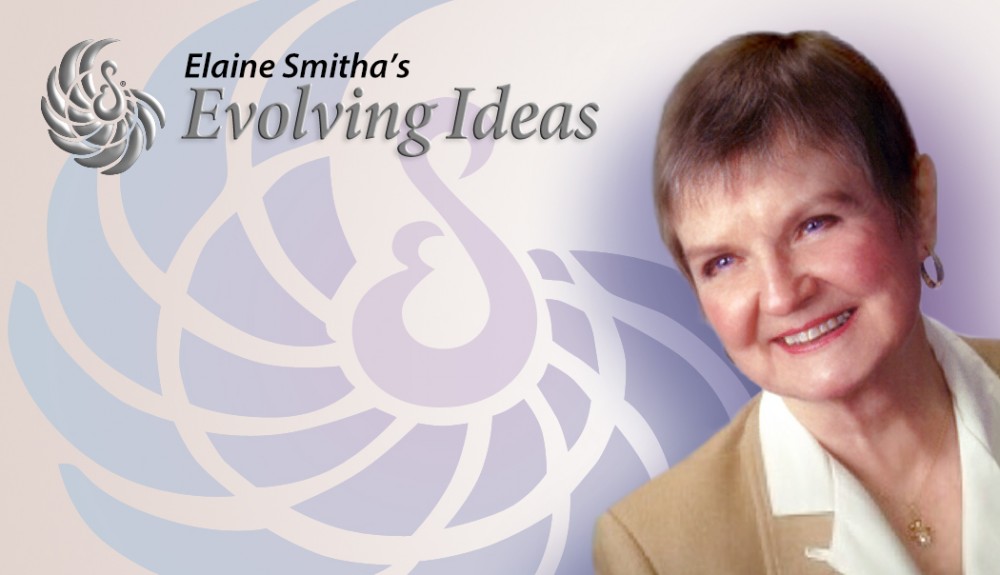 Elaine Smitha, Producer of Evolving Ideas. She has short brown hair, and is smiling at someone off screen. She is wearing a camel colored jacket and a white blouse.